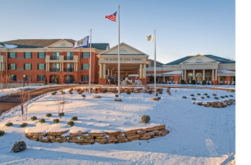 A large brick building with a snow-covered landscape, flags, and a sign that reads 