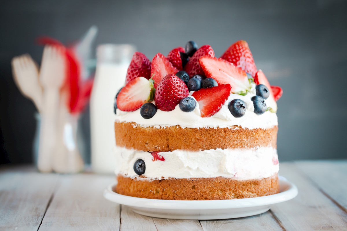 Photo shows a Sponge cake with strawberries, blueberries and cream